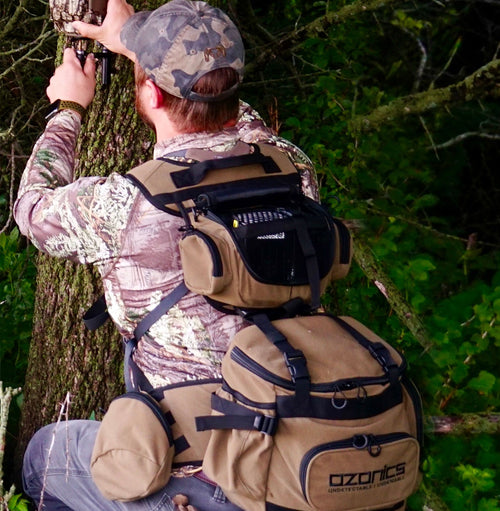 A Man Installing A Device On A Tree With Kinetic Bag On His Back.